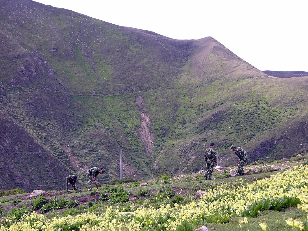 23 Soldiers Tilling Fields Above Nyalam I walked up the fields a few minutes above Nyalam and observed soldiers holding shovels and hoes, instead of guns, as they tend their vegetable plots.